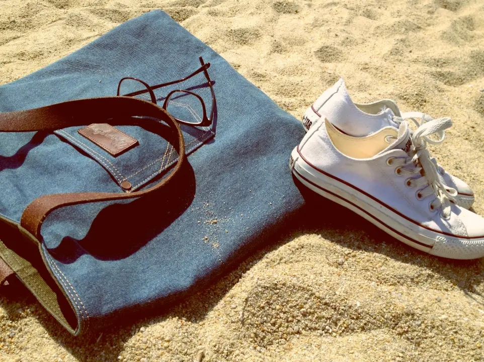 pair of white low-top sneakers on brown sand